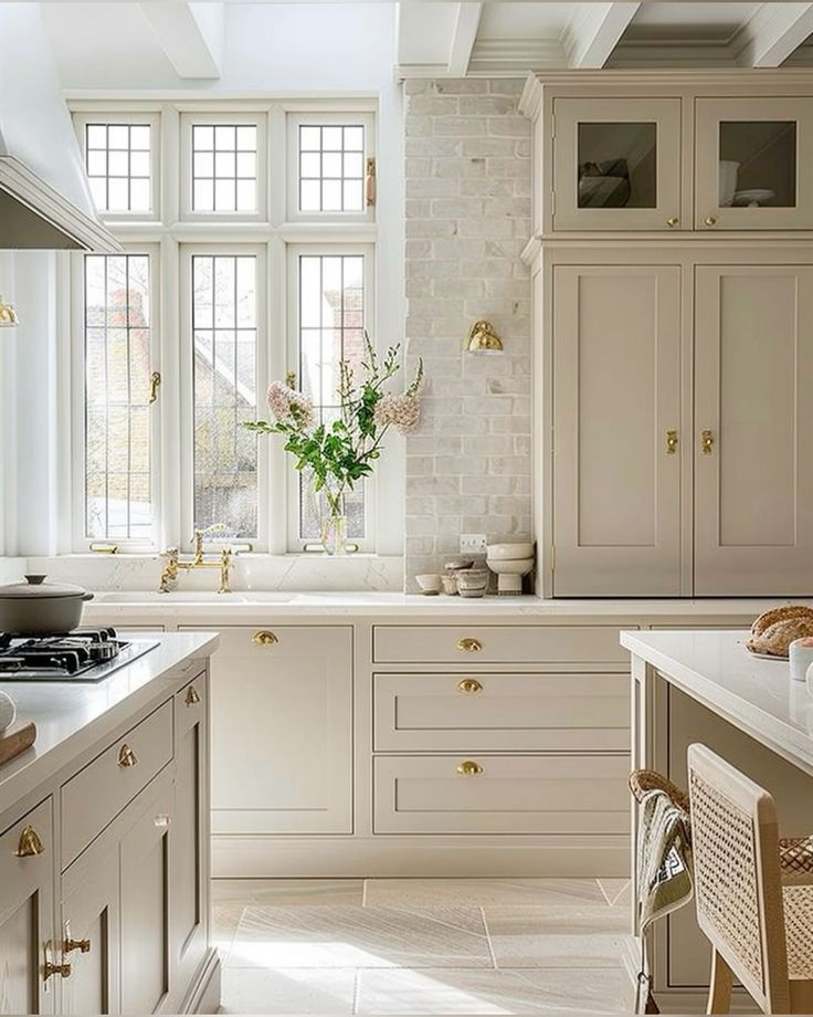 cream cabinets limestone backsplash tile brass hardware