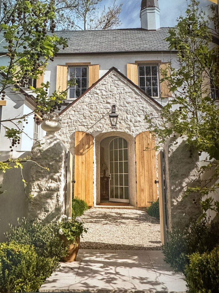 Velvet and Linen Stone portico arched entry wood shutters